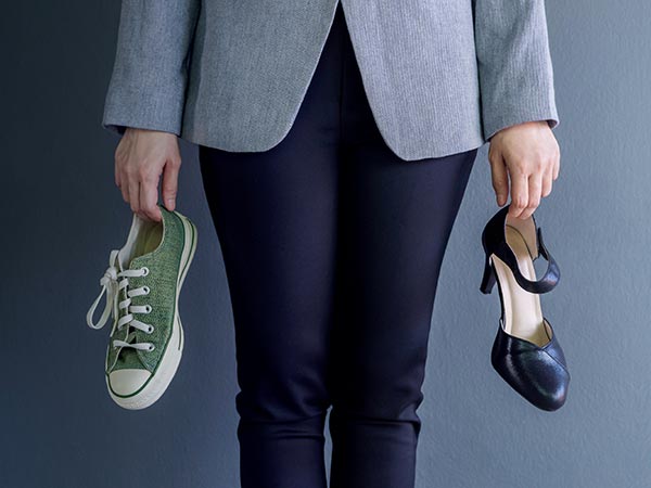woman holding casual and business shoes