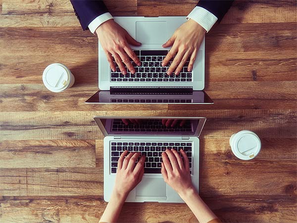 male and female hands using laptop