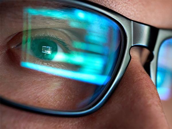 computer screen reflected in man's glasses