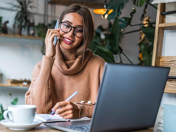 woman on phone and using laptop
