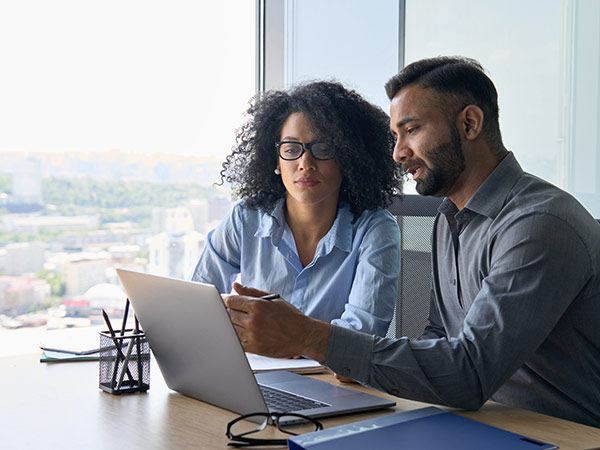 two colleagues looking at laptop